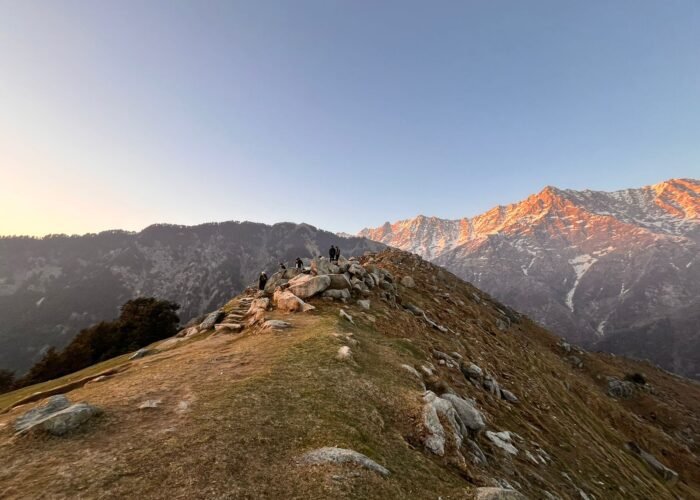 Scenic view of the Dhauladhar mountains with a trekking trail leading to Triund, promoting Hill Hikers' guided triund trek booking services.